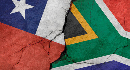 Chile and South Africa flags, concrete wall texture with cracks, grunge background, military conflict concept