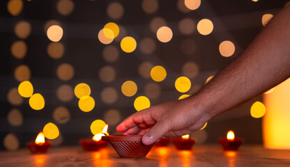 Diwali celebration image, Hand holding Diwali Diya isolated on bokeh background, Happy Diwali 2024...