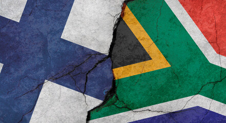 Finland and South Africa flags, concrete wall texture with cracks, grunge background, military conflict concept