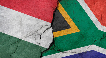 Hungary and South Africa flags, concrete wall texture with cracks, grunge background, military conflict concept