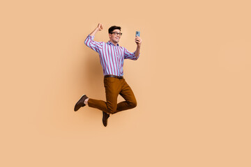 Fototapeta na wymiar Full length photo of cheerful man wear stylish clothes hand fist rejoice sale discount empty space isolated on beige color background