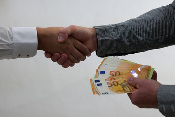 two guys shake hands and launder money, possible bribery or corruption - white background