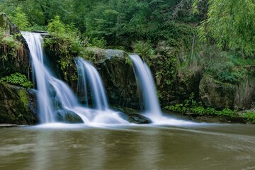 Long exposure view of a beautiful waterfall cascading between lush trees