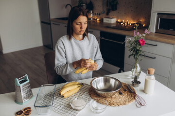 Beautiful woman prepares a banana muffin with berries for breakfast.  healthy homemade food...