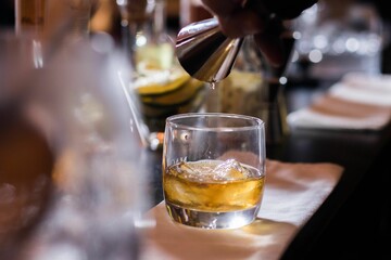 Closeup of the barman pouring whisky into a glass