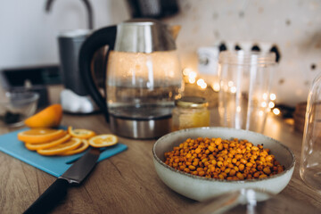 The process of preparing autumn winter sea buckthorn tea with orange, cinnamon and honey. Healthy drinks concept