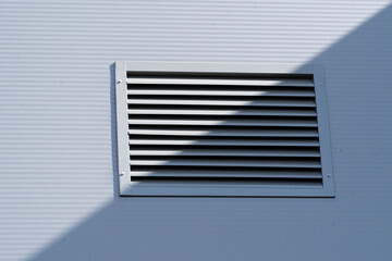 Air conditioning vent on a wall. Light and shadow. Duality concept. Contrast.