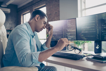 Photo of upset young man sit table suffer tiredness much code debugs javascript html stress job programmer working inside office room - obrazy, fototapety, plakaty
