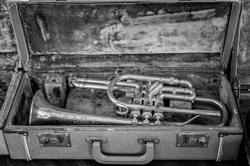 an old trumpet in a metal case on a wooden surface