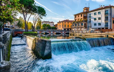 Zelfklevend Fotobehang Evening view of the San Martino bridge. Italian city of Treviso in the province of Veneto. View of the river Sile and the architecture of the city of Treviso Italy.  © Tryfonov