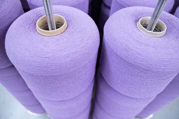 large bobbins of linen threads for lilac - colored fabrics .Flax processing plant, fabric production. Flax is produced .Workshop at a textile factory.