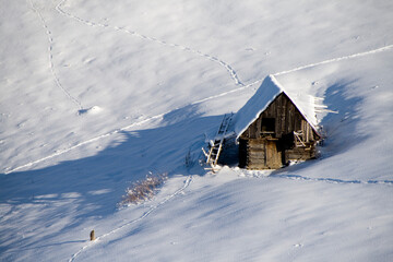 A cozy wooden cabin nestled in a vast snowy field