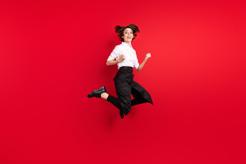 Full size photo of excited cheerful young woman jump up winner celebrate waitress isolated on red color background