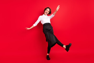 Full body photo of funky positive young woman dance good mood waitress isolated on red color...
