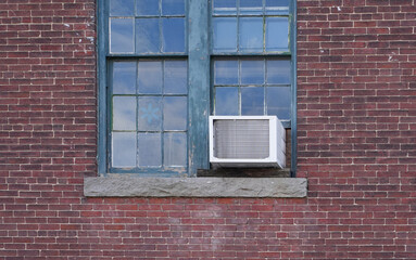 old air conditioner installed on rustic house window