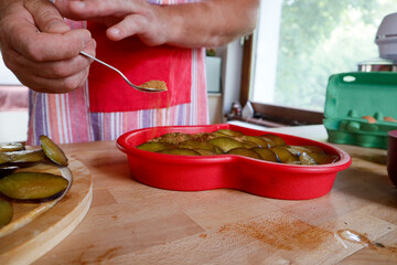 Hands of a man in a red apron preparing a pie in the kitchen, Valentines day