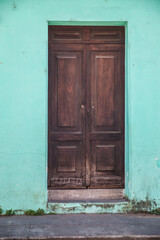 wooden door inside green wall 