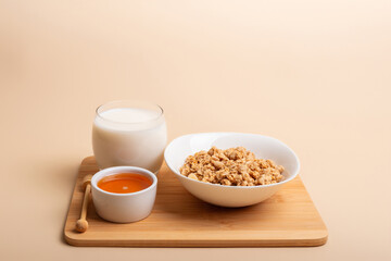 Plate of granola, glass of milk and honey for healthy breakfast. 