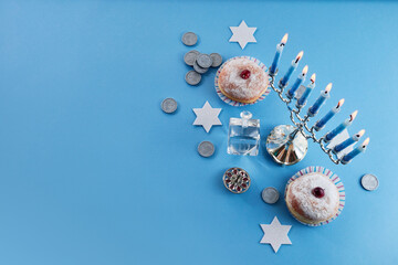 Jewish holiday Hanukkah with menorah, traditional Candelabra, donut and dreidel, spinning top.