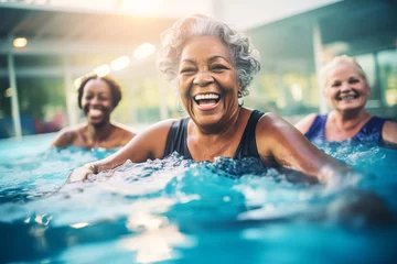 Fotobehang Multiracial Mature women having fun and doing water aerobics in pool © colnihko