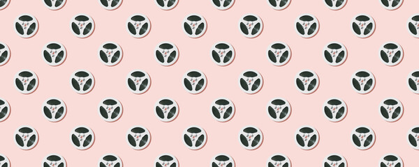 Seamless pattern of white reels for tape recorder isolated on pink background.