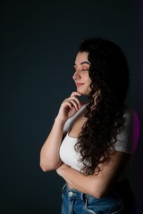 Young woman is looking away from the camera, her hands resting beneath her chin