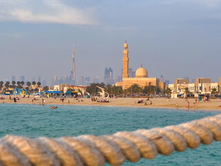Naklejka premium Dubai beach with the towering city skyscrapers in the background.