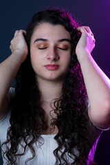 Young woman, styling her curly hair