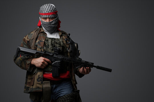Militant from the Middle East, dressed in a white keffiyeh and camouflaged field attire, wielding an automatic rifle, set against a neutral gray backdrop