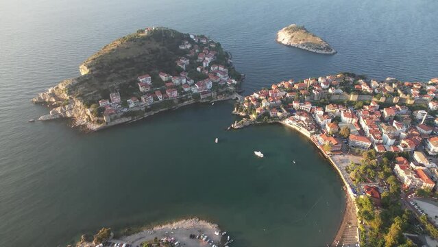 City view in the Amasra mountains. The drone is slowly approaching the beautiful landscape. Aerial view of houses and deep blue sea. Amasra, Turkey.