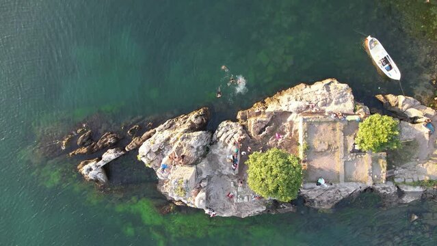 City view in the Amasra mountains. The drone is slowly approaching the beautiful landscape. Aerial view of houses and deep blue sea. Amasra, Turkey.