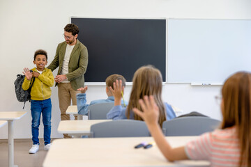Teacher introducing a new boy to the classmates