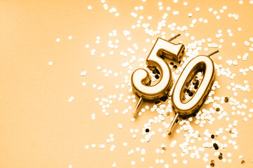 50 years celebration festive background made with golden candles in the form of number Fifty lying...