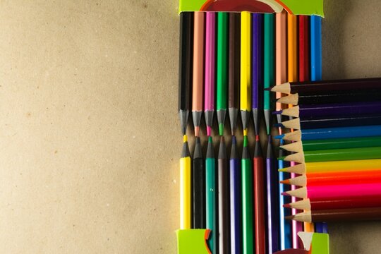 Vibrant assortment of colored pencils laid out on a wooden table