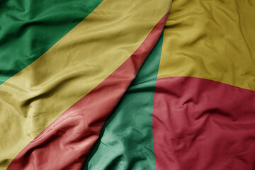 big waving national colorful flag of republic of the congo and national flag of benin .