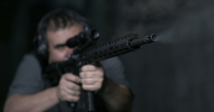 Man aiming an assult rigle and firing bullet in high-speed slow-motion 800 fps
