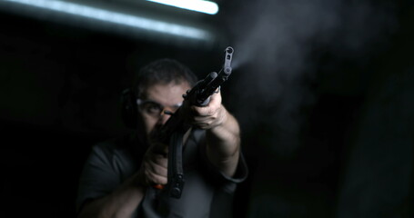 Man aiming and firing with weapon in super slow-motion 800 fps. Person holding an AK-47 Kalashnikov...