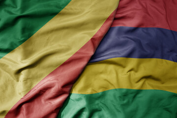 big waving national colorful flag of republic of the congo and national flag of mauritius .