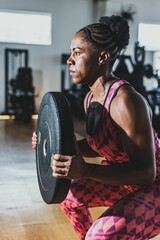 a woman squatting on the ground with a barbell