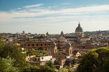 Fototapeta na wymiar Panorama of Rome with the dome of the basilica of San Carlo al Corso and the church of Sant'Atanasio dei Greci, as seen from Terrazza Viale del Belvedere