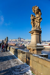 Baroque Statue on the Charles Bridge in the sunny snowy Day, Prague, Czech republic