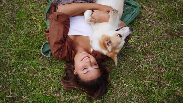 Blissful moments, a young woman and her dog Corgi savor serene outdoor companionship. photo above