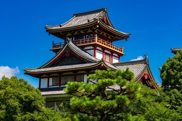 Obraz premium Traditional Chinese pagoda against a bright blue sky with white fluffy clouds in the background