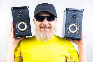 audio speakers in the hands of a bearded man. sound and modern media technologies