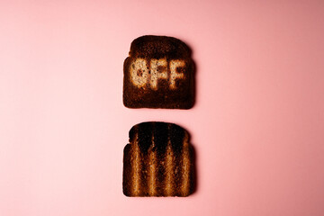 Burn off concept. Two slices of dark burnt charred white bread with word Off on it on pink background. Conceptual image 