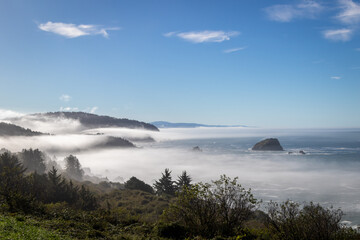 Highway 101 overlook looking down at Wilson creek beach, Image shows a view on top of a hill with low level clouds passing through the hills on a autumn's morning 