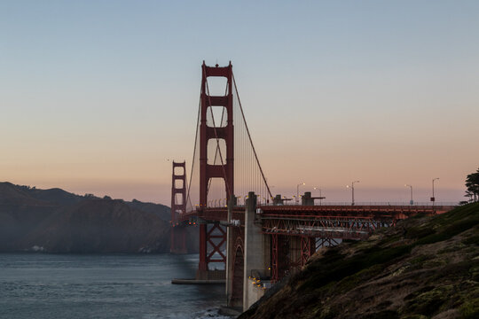golden gate bridge at sunset, image shows the 2737 meter long bridge built in 1937 on a warm evening with clear skies showing a array of sunset colours, taken october 2023