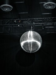 the light hangs from above a mirror disco ball in an auditorium