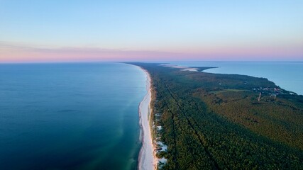 Curonian Spit National Park at sunset, aerial shot. A narrow and long sandy strip of land separating the Curonian Lagoon from the Baltic Sea. Forest and sea. Drone view - obrazy, fototapety, plakaty