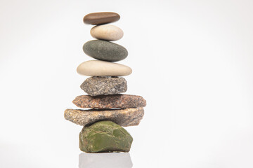 pyramid of stacked stones on a white background. stabilization and balance in life